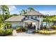 Elegant community clubhouse featuring a gated entrance, lush landscaping, and a glimpse of the sparkling community pool at 19836 Bridgetown Loop, Venice, FL 34293