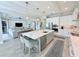 Bright kitchen with white cabinets, stainless steel appliances, a large island with seating and pendant lights at 19836 Bridgetown Loop, Venice, FL 34293