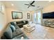 Open living room with sliding glass doors, a gray sectional and a white coffee table at 19836 Bridgetown Loop, Venice, FL 34293