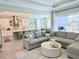 Bright open living room flowing into the kitchen features modern lighting and stainless steel appliances at 19836 Bridgetown Loop, Venice, FL 34293