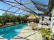 Inviting in-ground pool with a screened enclosure, patio table, and a poolside lounge area at 19836 Bridgetown Loop, Venice, FL 34293