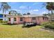 Backyard view of a one story house with a well-maintained lawn and a utility trailer at 200 Pameto Rd, Nokomis, FL 34275