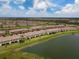 Beautiful aerial view of waterfront townhomes with tile roofs and lush green lawns in a Primary-planned community at 20390 Lagente Cir, Venice, FL 34293