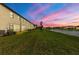 Backyard view featuring lush grass, a lake, and a gorgeous pink and blue sunset at 20390 Lagente Cir, Venice, FL 34293