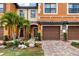 Townhome with desert landscaping, brick driveway, and a two-car garage at 20390 Lagente Cir, Venice, FL 34293