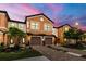 Townhome with desert landscaping, brick driveways, and two-car garage under an evening sky at 20390 Lagente Cir, Venice, FL 34293