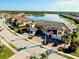 Aerial shot showcases lakeside townhomes with brick paver driveways, lush landscaping, and serene water views at 23194 Banbury Way # 202, Venice, FL 34293