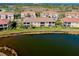 Aerial view features waterfront condos with balconies overlooking a serene lake, surrounded by lush greenery and mature trees at 23194 Banbury Way # 202, Venice, FL 34293