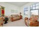 Cozy sitting area with a plush loveseat and armchair bathed in natural light at 23194 Banbury Way # 202, Venice, FL 34293