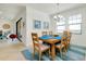 Light and airy dining room features a wood table, seating for six, and views of the living room at 23194 Banbury Way # 202, Venice, FL 34293