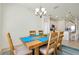 Light and airy dining room features a wood table, seating for six, and modern chandelier at 23194 Banbury Way # 202, Venice, FL 34293