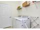 Functional laundry room with new washer and dryer, storage shelves, and drying rack at 23194 Banbury Way # 202, Venice, FL 34293