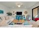 Comfortable living room features a ceiling fan, stylish blue accents, and neutral-toned furniture at 23194 Banbury Way # 202, Venice, FL 34293