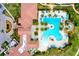 Aerial view of a luxurious community pool area with ample seating, palm trees, and resort-style amenities at 23194 Banbury Way # 202, Venice, FL 34293