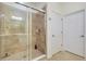 Tiled shower with glass door in bathroom next to door leading to walk-in closet at 23194 Banbury Way # 202, Venice, FL 34293