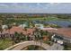 An aerial view of the community with swimming pool, clubhouse, lush landscaping, golf course and lake at 24065 Canterwood Way, Venice, FL 34293