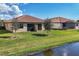 A beautiful backyard featuring a screened in patio, lush lawn, and a serene pond view at 24065 Canterwood Way, Venice, FL 34293