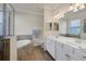 Bathroom featuring double vanity sinks, walk-in shower, and a soaking tub at 24065 Canterwood Way, Venice, FL 34293