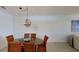 The dining room features a round table with seating for six, a decorative chandelier, and tile flooring at 24065 Canterwood Way, Venice, FL 34293