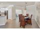 Cozy dining room featuring a wooden table, woven chairs, and an elegant chandelier lighting the space at 24065 Canterwood Way, Venice, FL 34293