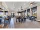 The dining room features tables with padded chairs, a bar, multiple windows and hexagon patterned flooring at 24065 Canterwood Way, Venice, FL 34293