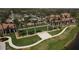 Expansive manicured green lawn with palm trees in front of a stately building on a bright day at 24065 Canterwood Way, Venice, FL 34293