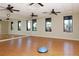 Bright fitness center featuring hardwood floors, mirrored wall, and large windows overlooking lush landscaping at 24065 Canterwood Way, Venice, FL 34293