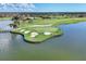 Scenic aerial of a golf course island surrounded by water, with sand traps and manicured greens at 24065 Canterwood Way, Venice, FL 34293