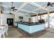 Outdoor pool bar area with a modern design, including ceiling fans, tiled walls and table seating at 24065 Canterwood Way, Venice, FL 34293