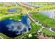 Overhead shot of a golf course, lush landscaping, and placid lakes surrounding a housing development at 24229 Spartina Dr, Venice, FL 34293