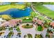 An aerial view of clubhouse featuring circular drive, manicured landscaping, and golf course in the background at 24229 Spartina Dr, Venice, FL 34293