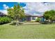 Backyard featuring a screened-in lanai and well-manicured lawn at 24229 Spartina Dr, Venice, FL 34293