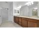 Bright bathroom featuring a double sink vanity with granite countertop, large mirror, and walk-in shower at 24229 Spartina Dr, Venice, FL 34293