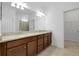 Bright bathroom with double sink vanity, granite countertop, and modern lighting fixtures over a large mirror at 24229 Spartina Dr, Venice, FL 34293