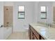 Bright bathroom features a granite-topped vanity and tiled shower-tub combination at 24229 Spartina Dr, Venice, FL 34293