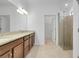 Bright bathroom featuring a double sink vanity with granite countertop and a glass-enclosed shower at 24229 Spartina Dr, Venice, FL 34293