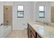 Bright bathroom features a granite-topped vanity and tiled shower-tub combination at 24229 Spartina Dr, Venice, FL 34293