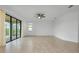 Bright bedroom featuring neutral tile flooring, fan, and a sliding glass door leading to the outside at 24229 Spartina Dr, Venice, FL 34293