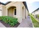 Exterior view shows the archways, stucco, paver walkway and lush landscaping around the house at 24229 Spartina Dr, Venice, FL 34293