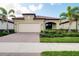 Inviting single-story home featuring a brick driveway, two-car garage, and lush landscaping at 24229 Spartina Dr, Venice, FL 34293