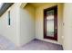 Front door view featuring leaded glass, terracotta pavers and neutral stucco at 24229 Spartina Dr, Venice, FL 34293