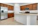 Spacious kitchen featuring granite countertops, stainless steel appliances, a center island, and wood cabinets at 24229 Spartina Dr, Venice, FL 34293