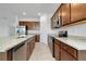 Close up of kitchen island with granite countertops, stainless steel appliances, and wooden cabinetry at 24229 Spartina Dr, Venice, FL 34293