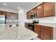 Close up of kitchen island with granite countertops, stainless steel appliances, and wooden cabinetry at 24229 Spartina Dr, Venice, FL 34293