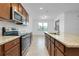 Well-lit kitchen features stainless appliances, granite countertops, and ample cabinet space at 24229 Spartina Dr, Venice, FL 34293