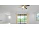 Bright living room featuring neutral tile flooring, a fan, and a sliding glass door leading to the outside at 24229 Spartina Dr, Venice, FL 34293