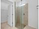 Modern shower featuring a seamless glass enclosure and tiled walls with a window for natural light at 24229 Spartina Dr, Venice, FL 34293