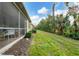 Landscaped backyard with screened patio and lush greenery at 27231 Ipswich Dr, Englewood, FL 34223