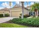 Two-car garage, mature landscaping, and a bird statue at 27231 Ipswich Dr, Englewood, FL 34223