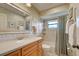 Charming bathroom featuring patterned wall paper, framed mirror over a single sink vanity, and shower/tub combo at 302 Woodingham Ct, Venice, FL 34292